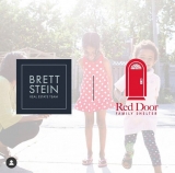 A faded photo of two girls playing with Red Door's and Brett Stein Real Estate Team's logos overlayed