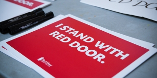 A sign that reads "I stand with a Red Door"